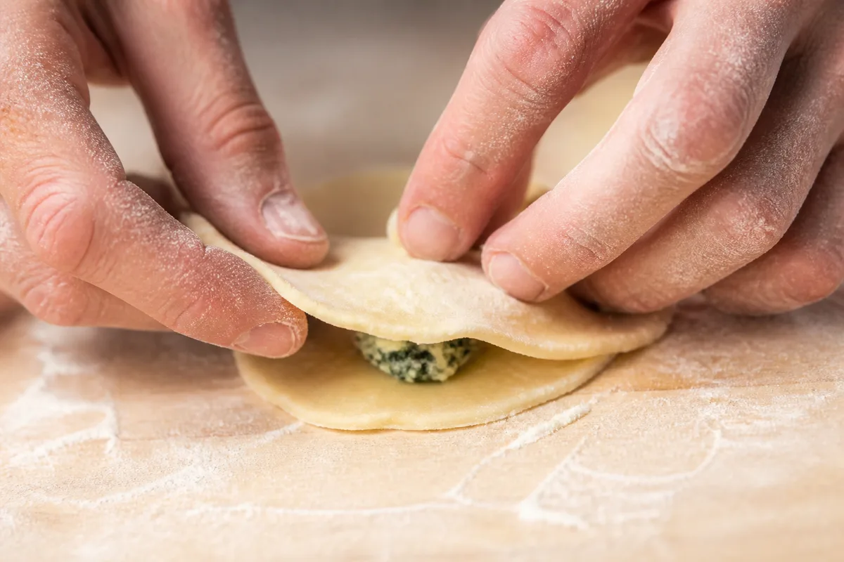 Pâte farcie fraîche façonnée à la main sur un plan de travail fariné